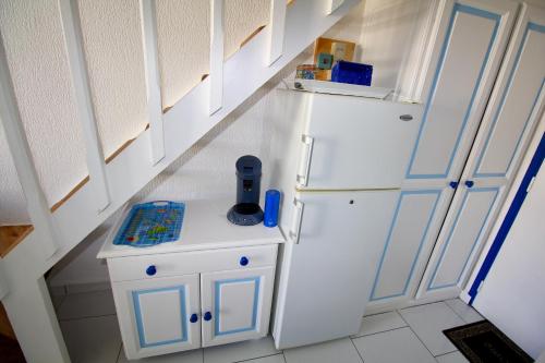 a small kitchen with a white refrigerator and cabinets at BlueDreamVacances Marines IV in Saint-François