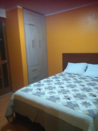 ein Schlafzimmer mit einem Bett, einem Schrank und einer Tür in der Unterkunft PYMABET in Huancavelica