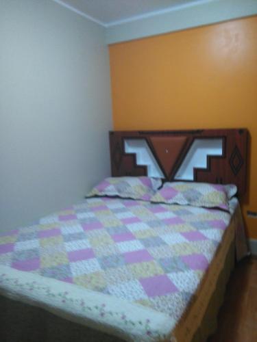een slaapkamer met een bed met een quilt bij PYMABET in Huancavelica