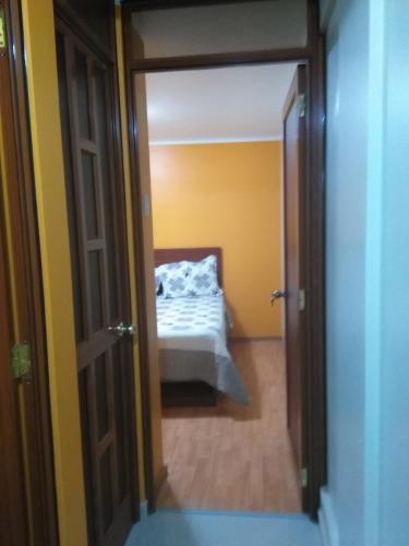 een slaapkamer met een bed door een deur bij PYMABET in Huancavelica