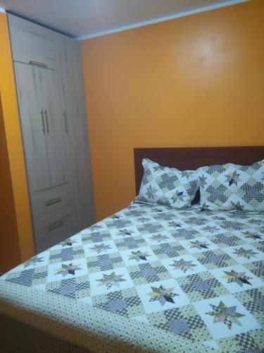 1 dormitorio con 1 cama con edredón en PYMABET, en Huancavelica