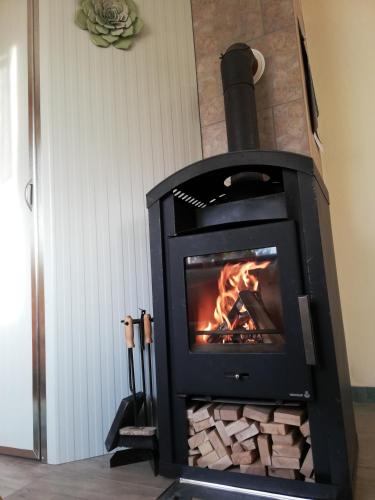 a black stove with a fire in a room at Holiday Home Forest Peace, Lavrovec in Hlevni Vrh