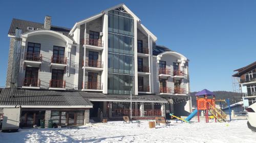 un gran edificio con un parque infantil delante de él en 2 Room Deluxe Apartment in Bakuriani, en Bakuriani