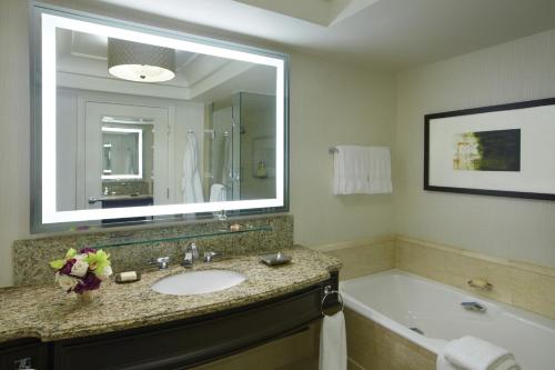 a bathroom with a sink and a tub and a mirror at Four Seasons Hotel Las Vegas in Las Vegas