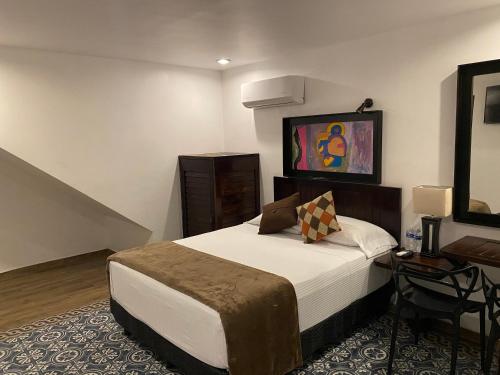 a hotel room with a bed and a table at Hotel Raices de Mar in Mazatlán