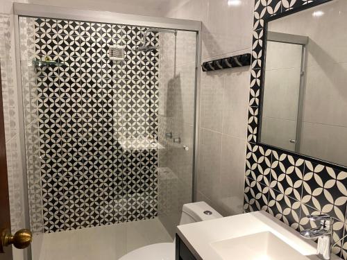 a bathroom with a shower with a toilet and a sink at Hotel Raices de Mar in Mazatlán