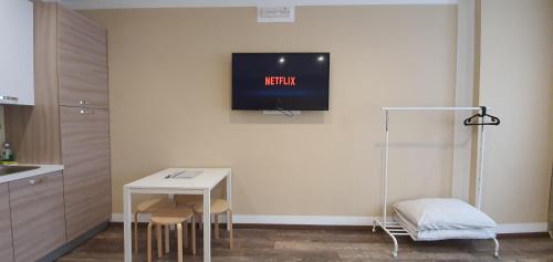 a kitchen with a table and a tv on the wall at Bsuites Scrovegni in Padova