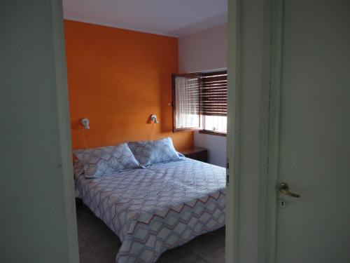 um pequeno quarto com uma cama e uma janela em El Buen Descanso em Gualeguaychú