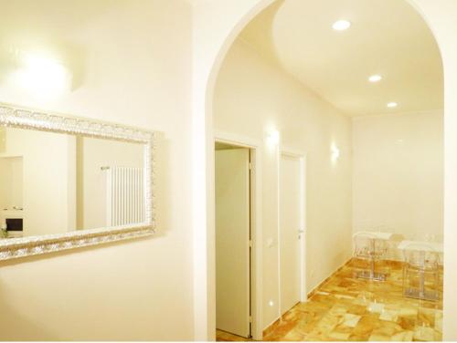 a white room with a mirror and a hallway at Manila Inn in Rome