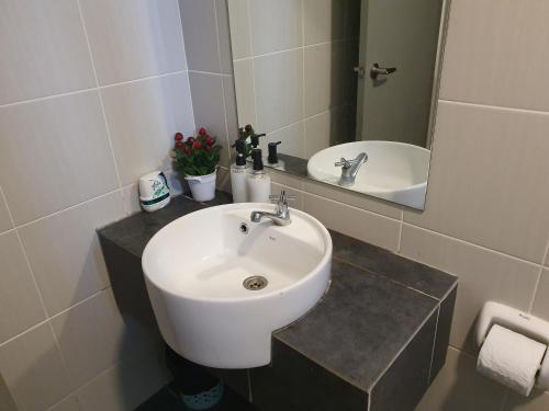 a bathroom with a white sink and a mirror at MHB 30 SUlTE EVO SOHO BANDAR BARU BANGI FREE NETFLIX AND WIFI in Bangi