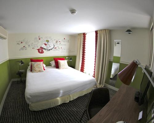 Ein Bett oder Betten in einem Zimmer der Unterkunft Hôtel des 3 Poussins