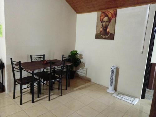 uma sala de jantar com uma mesa e cadeiras e um quadro em Habitaciones el corral em Aguacate