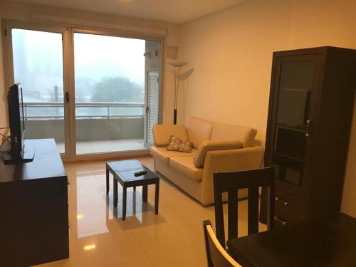 ein Wohnzimmer mit Sofa und Tisch in der Unterkunft La mansa in Puerto Madryn