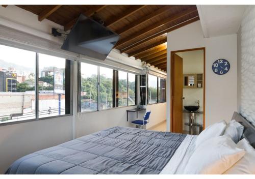 een slaapkamer met een groot bed en een groot raam bij Studios Exito in Medellín