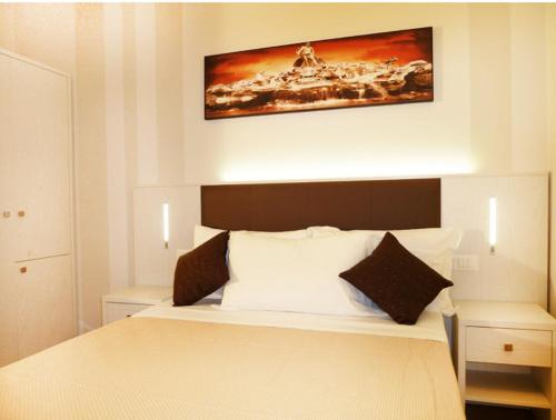 - une chambre dotée d'un lit avec une photo sur le mur dans l'établissement Manila Inn, à Rome