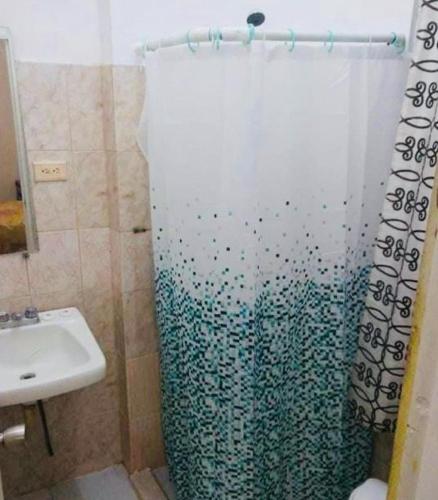 a bathroom with a shower curtain and a sink at Caribbean Hotel Santo Domingo in Santo Domingo
