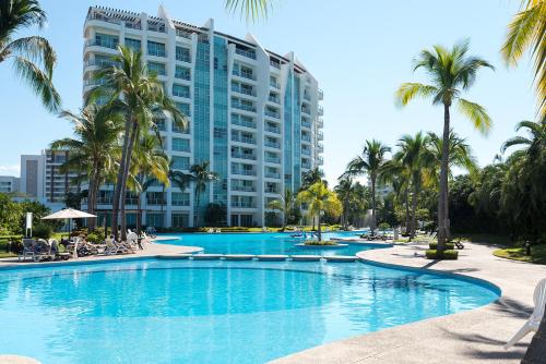 a swimming pool in front of a large building at Condo en Nuevo Vallarta con acceso a playa in Mezcales