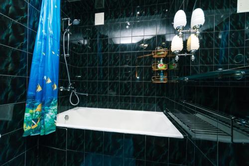 a black tiled bathroom with a sink and a mirror at 1 комнатная квартира м Васильковская газ и низкий этаж in Kyiv