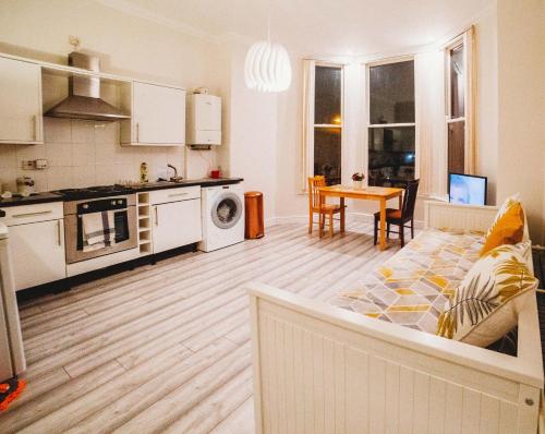 a kitchen and living room with a couch and a table at Cosy Apartment in Safe Area in Liverpool