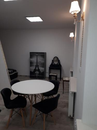 a room with a table and chairs and a clock at Apartament centrum Sienkiewicza WIEŻA EIFFLA PROMENADA -KLIMATYZACJA- WYJĄTKOWY in Kielce