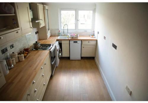 een keuken met een wastafel en een fornuis top oven bij Double bedroom in ashared flat in Sutton