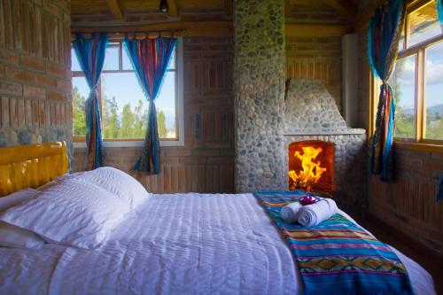 een slaapkamer met een bed en een open haard bij Watzara Wasi Cottage Familiar Camprestre Y Lofts en Cotacachi in Cotacachi