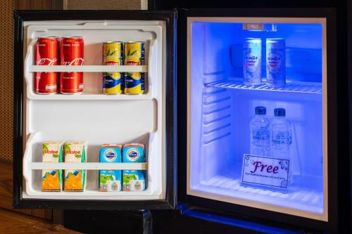 an open refrigerator filled with drinks and soda at Chala Number6 in Chiang Mai