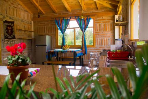 Il comprend une cuisine avec un évier et une table. dans l'établissement Watzara Wasi Cottage Familiar Camprestre Y Lofts en Cotacachi, à Cotacachi