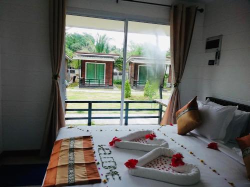 Un dormitorio con una cama con flores rojas. en Phumiphat resort Koh Mook en Trang