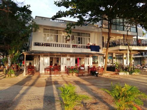 un edificio con mesas y sillas delante de él en Tony Home and Restaurant, en Karon Beach
