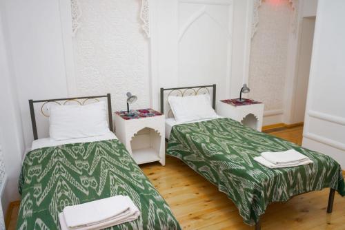 two beds sitting next to each other in a room at B-House Hotel in Bukhara