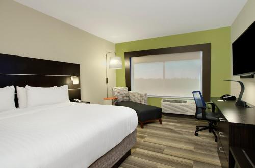 a hotel room with a large bed and a desk at Holiday Inn Express & Suites - Brookshire - Katy Freeway, an IHG Hotel in Brookshire