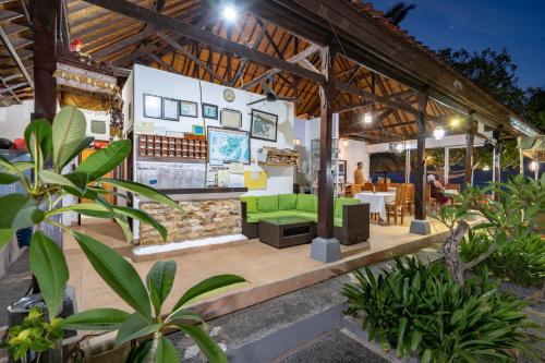 a patio with a green couch in a building at Nusa Indah Bungalow in Nusa Lembongan