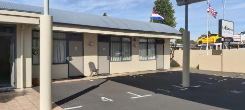 a building with a chair in a parking lot at Academy Motor Inn in Tauranga