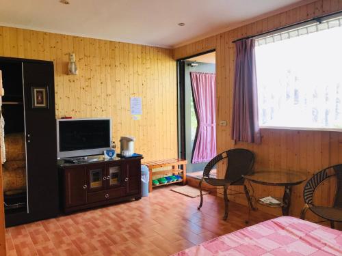 Televízia a/alebo spoločenská miestnosť v ubytovaní Huayi Homestay