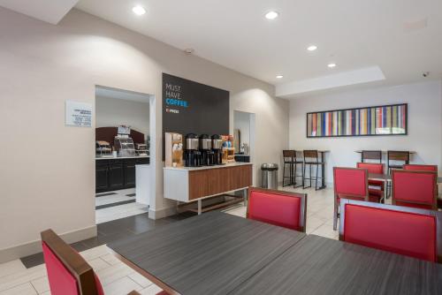 een eetkamer met een tafel en rode stoelen bij Holiday Inn Express Hotel & Suites Lagrange I-85 by IHG in LaGrange