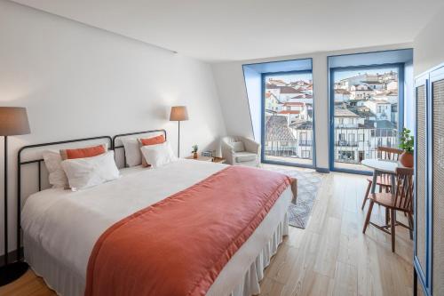 - une chambre avec un grand lit et un balcon dans l'établissement Loja Sr Costa by Casas com Estória Boutique Houses, à Santa Comba Dão