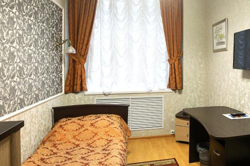 キーロフにあるHotel Preobrazhenskayaのベッドルーム1室(ベッド1台、窓、デスク付)