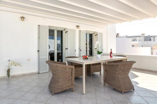 a dining room with a white table and chairs at Panos Apartment Naousa in Naousa