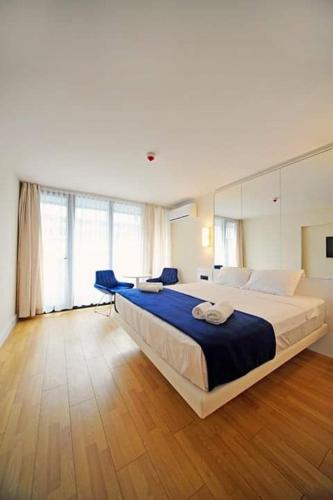 a large bedroom with a large bed with blue sheets at Apartment Twin Towers David in Batumi