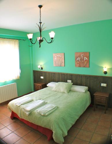 a bedroom with a large bed with green walls at Casas Rurales VegaSierra in Bogarra