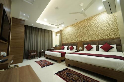 um quarto de hotel com duas camas com almofadas vermelhas em hotel s.s royal em Amritsar