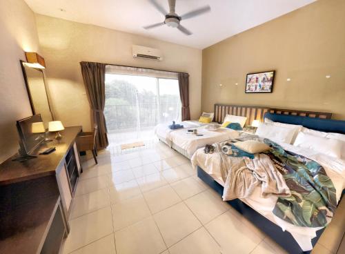 a hotel room with two beds and a television at Gold Coast Morib Themepark View Studio in Banting