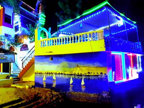 a lit up building with boats in the water at night at Bob Marley Guest House in Aswan