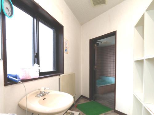 a bathroom with a sink and a window and a shower at Nanakuraso in Omachi