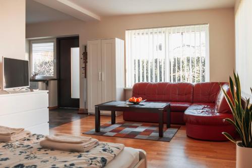 a living room with a red couch and a table at Agnės svečių namai in Kaunas