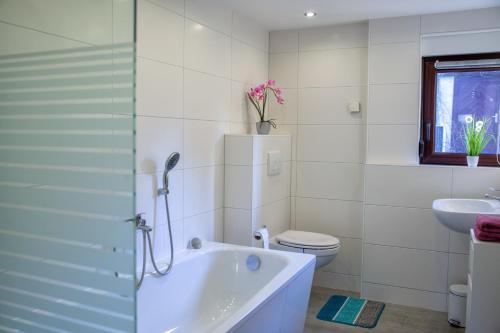 uma casa de banho com uma banheira, um WC e um lavatório. em Ferienhaus am Reiterhof em Templin