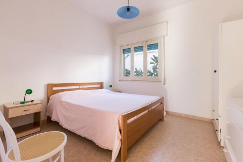 a white bedroom with a bed and a window at Villa Tabu' by BarbarHouse in Porto Cesareo
