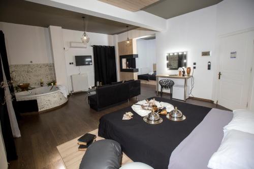 a living room with a bed and a living room with a tub at Cavallari Palace Hotel Suites in Athens