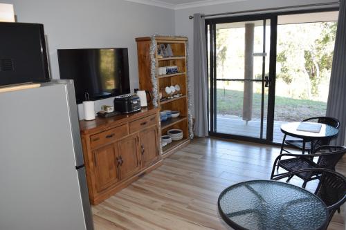 a living room with a television and a table and chairs at Eagle Bay House in Dunsborough